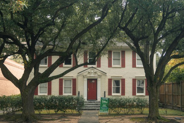 Classic colonial house with red shutters and trees in Houston, Texas, available for lease.