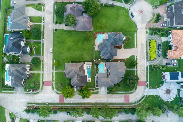Drone shot of suburban houses with pools in Houston, TX, from above.