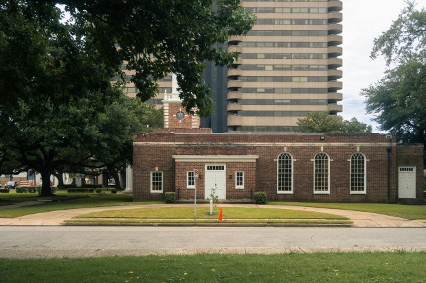 A timeless brick building set against modern skyscrapers downtown Houston, Texas.