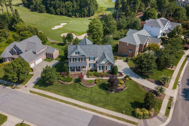 Aerial shot showcasing suburban homes and lush greenery in Raleigh, NC.